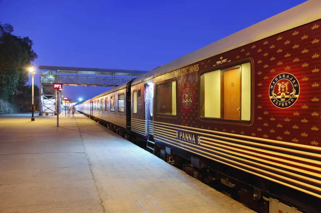 Voitures rouges du Maharajas’ Express dans une gare indienne de nuit