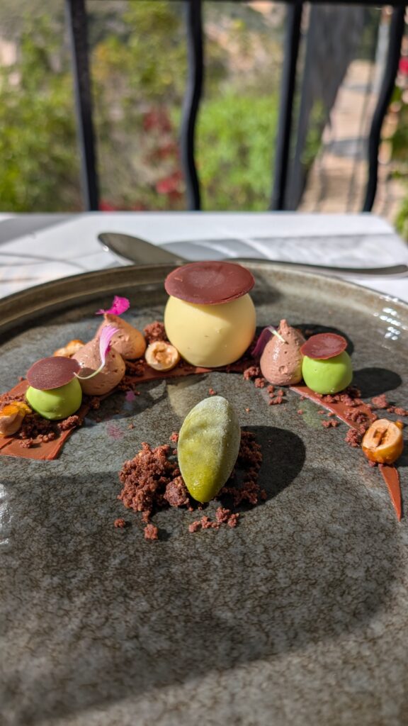 Dessert au citron, à la noisette et au chocolat, avec sphères jaunes et vertes et sorbet au basilic