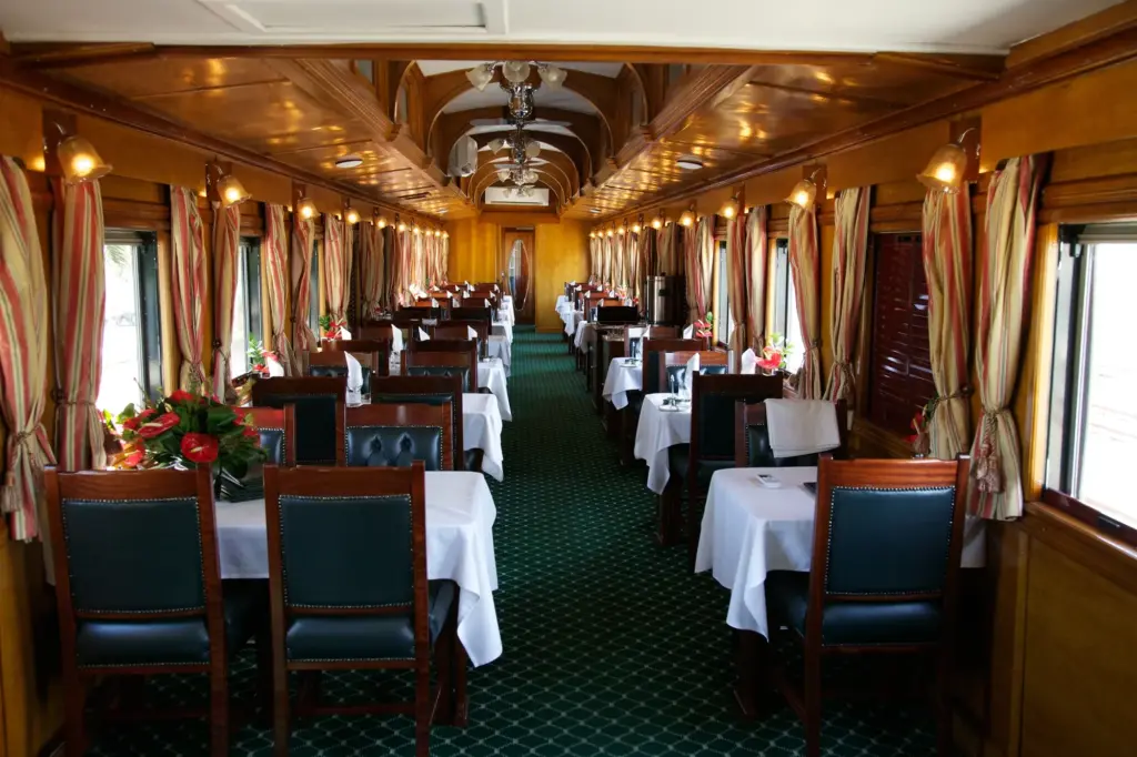 Intérieur en bois et tables dressées de la voiture-restaurant Rovos Rail