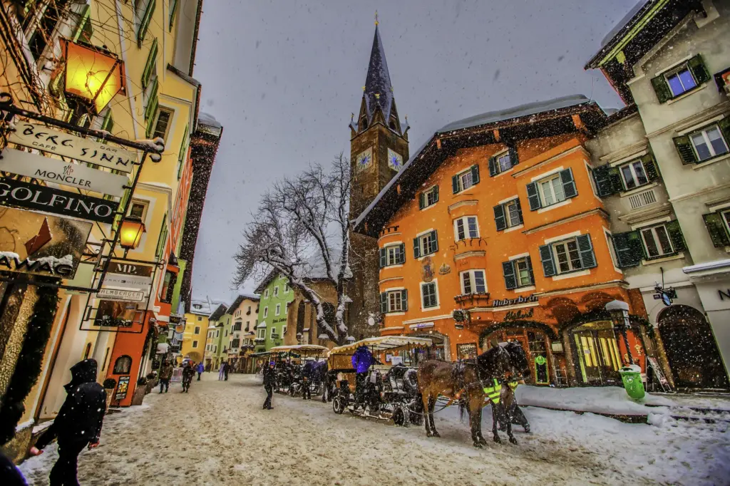 Rue de Kitzbühel bordée de façades colorées et d’enseignes, en hiver