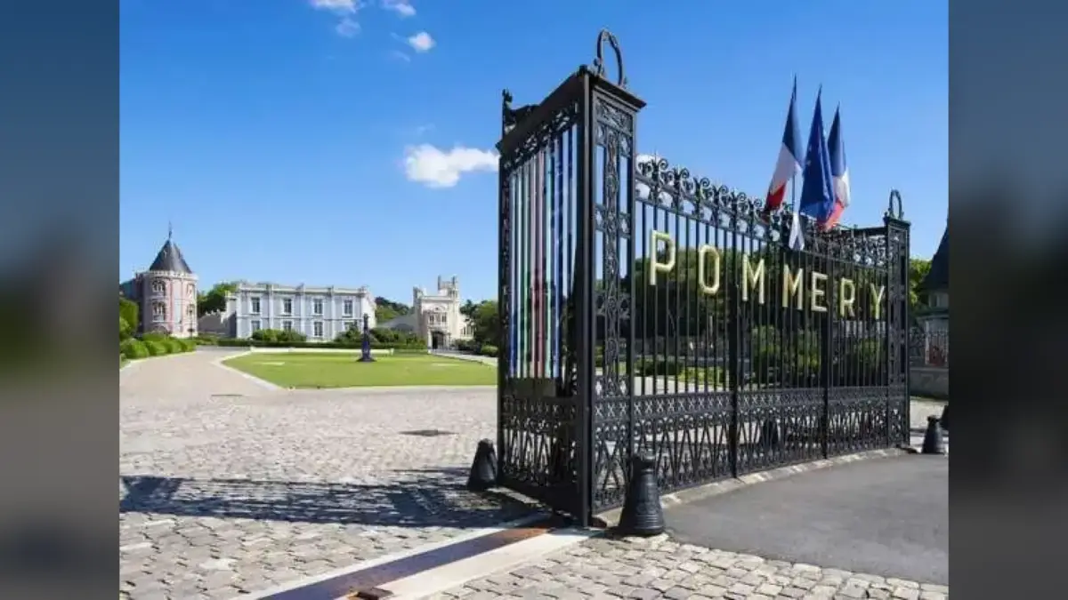 Grille d’entrée du domaine Pommery à Reims, avec drapeaux et bâtiments en arrière-plan