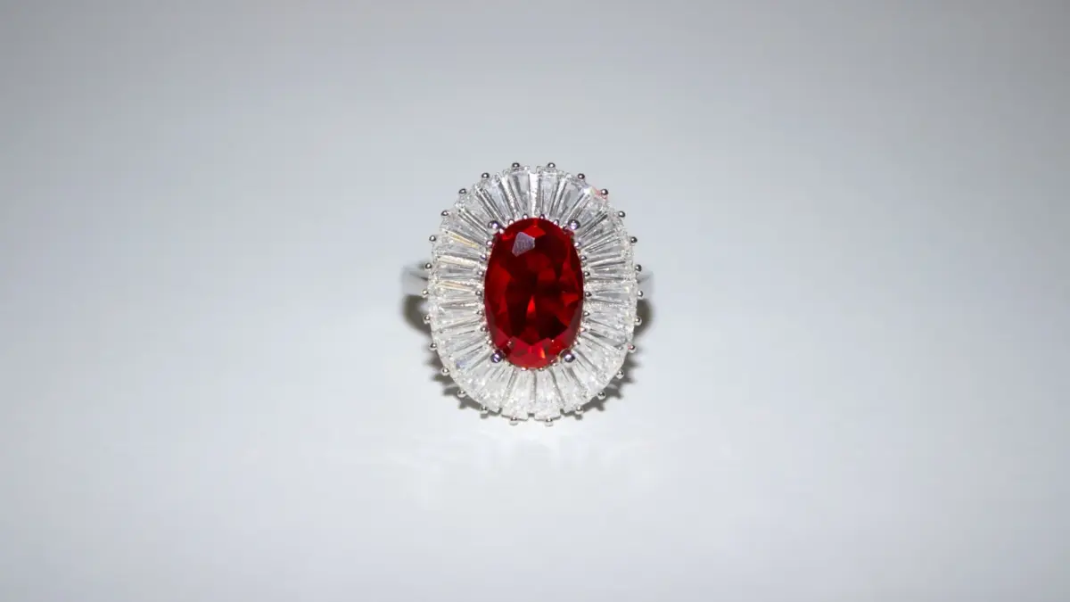 Bague de fiançailles en or blanc avec rubis ovale entouré de diamants baguette