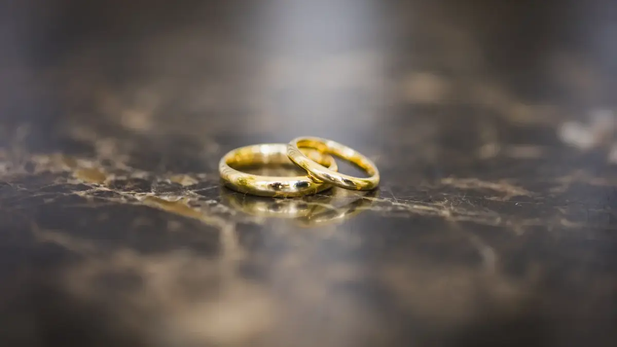Deux bagues en or dix-huit carats posées sur une surface sombre réfléchissante