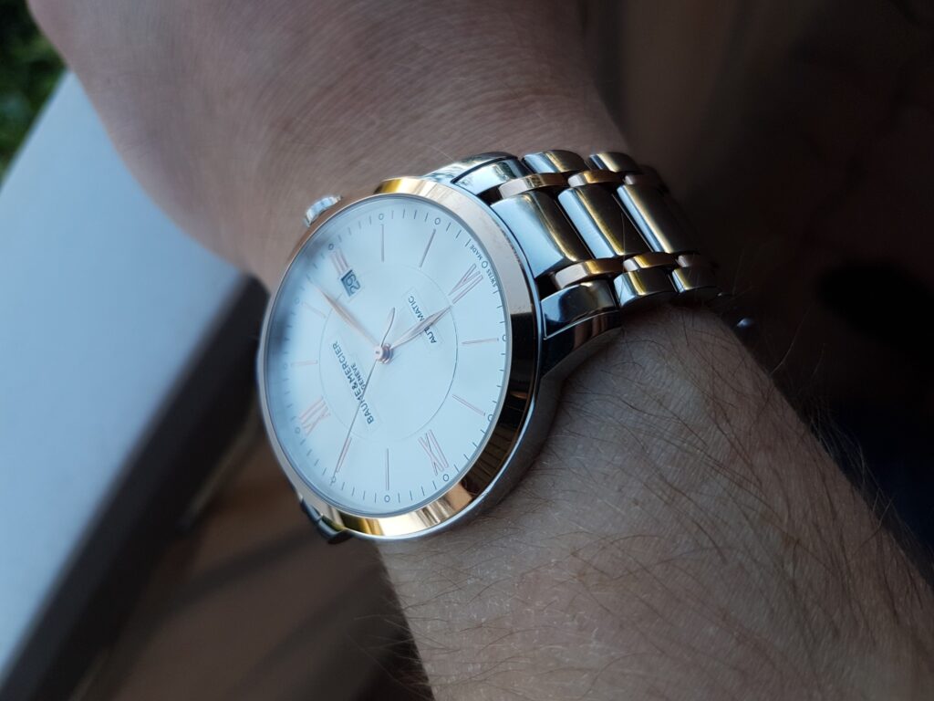 Gros plan de la Baume & Mercier Classima 10217 au poignet, avec son cadran clair et son bracelet bicolore