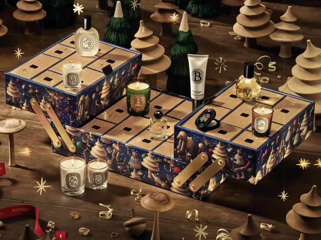 Calendrier de l’Avent Diptyque 2026 ouvert, bougies et flacons dans un décor de forêt en bois tourné