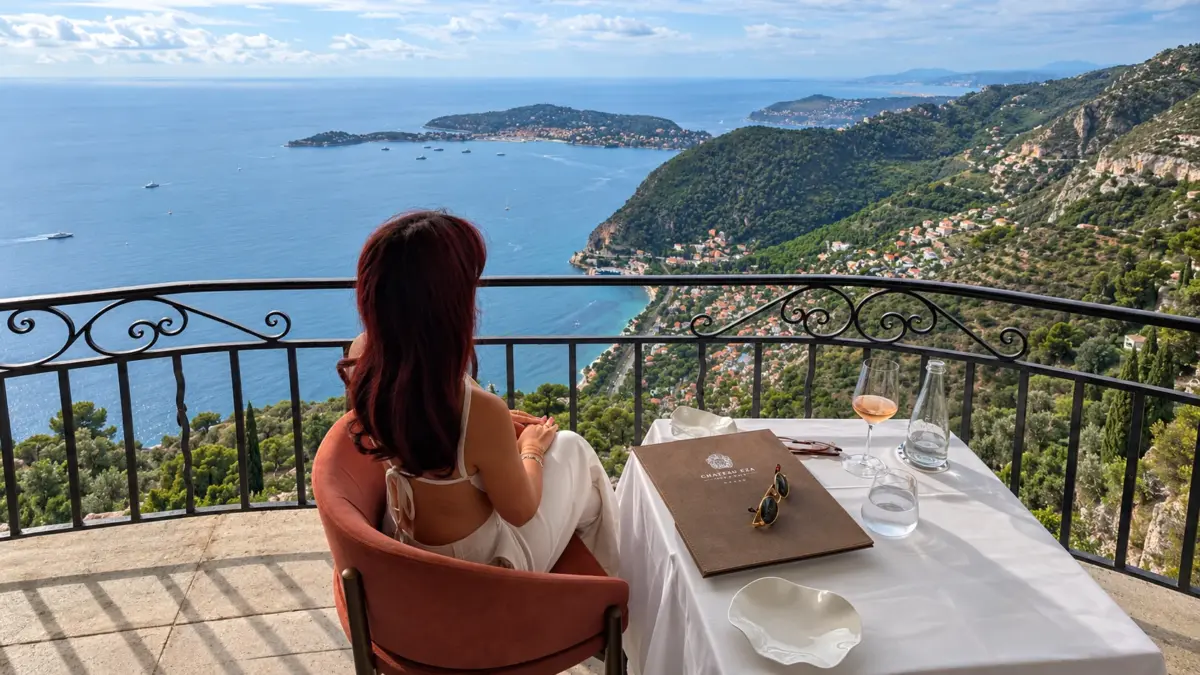 Déjeuner sur le balcon du restaurant Château Eza à Èze, face à la Méditerranée et à Saint-Jean-Cap-Ferrat, verre de rosé et carte posés sur la table
