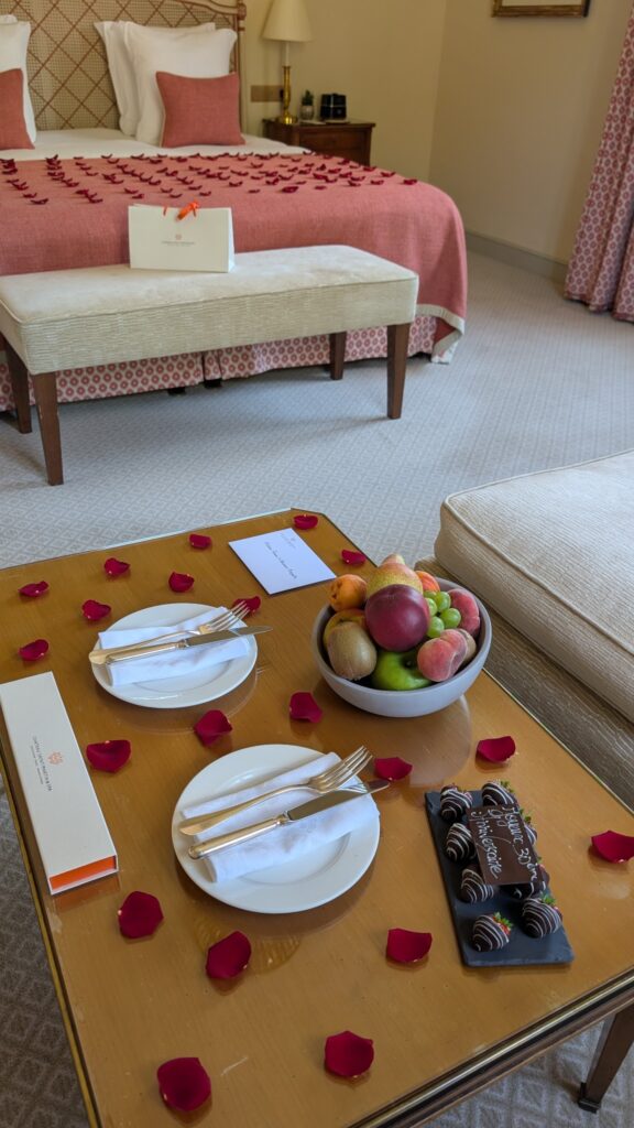 Pétales de roses, corbeille de fruits et attentions gourmandes en chambre