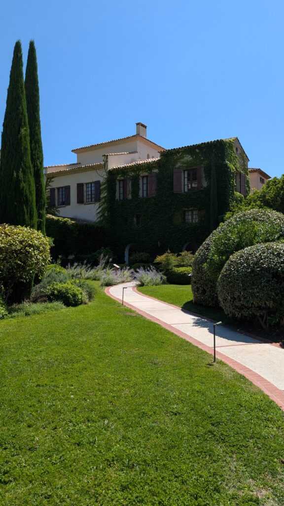 Façade du Château Saint-Martin & Spa, lierre et cyprès dans les jardins