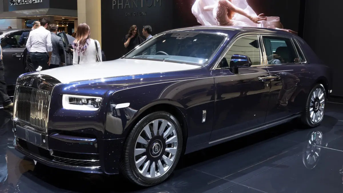 Rolls-Royce Phantom bleu nuit exposée dans un salon automobile au sol brillant