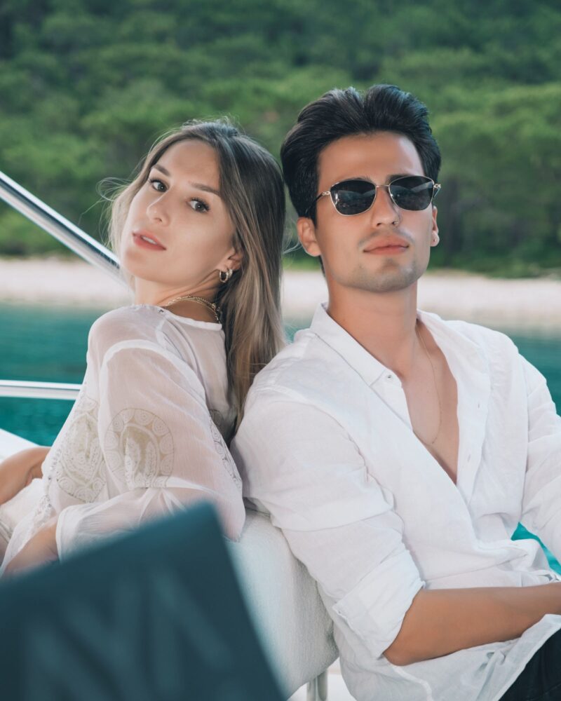 Couple en blanc sur le pont d'un yacht, lunettes de soleil