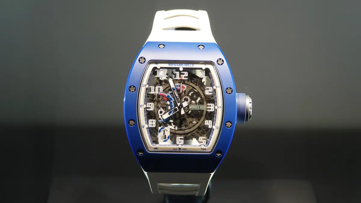 Montre Richard Mille à boîtier bleu, cadran squelette et bracelet blanc sur fond sombre