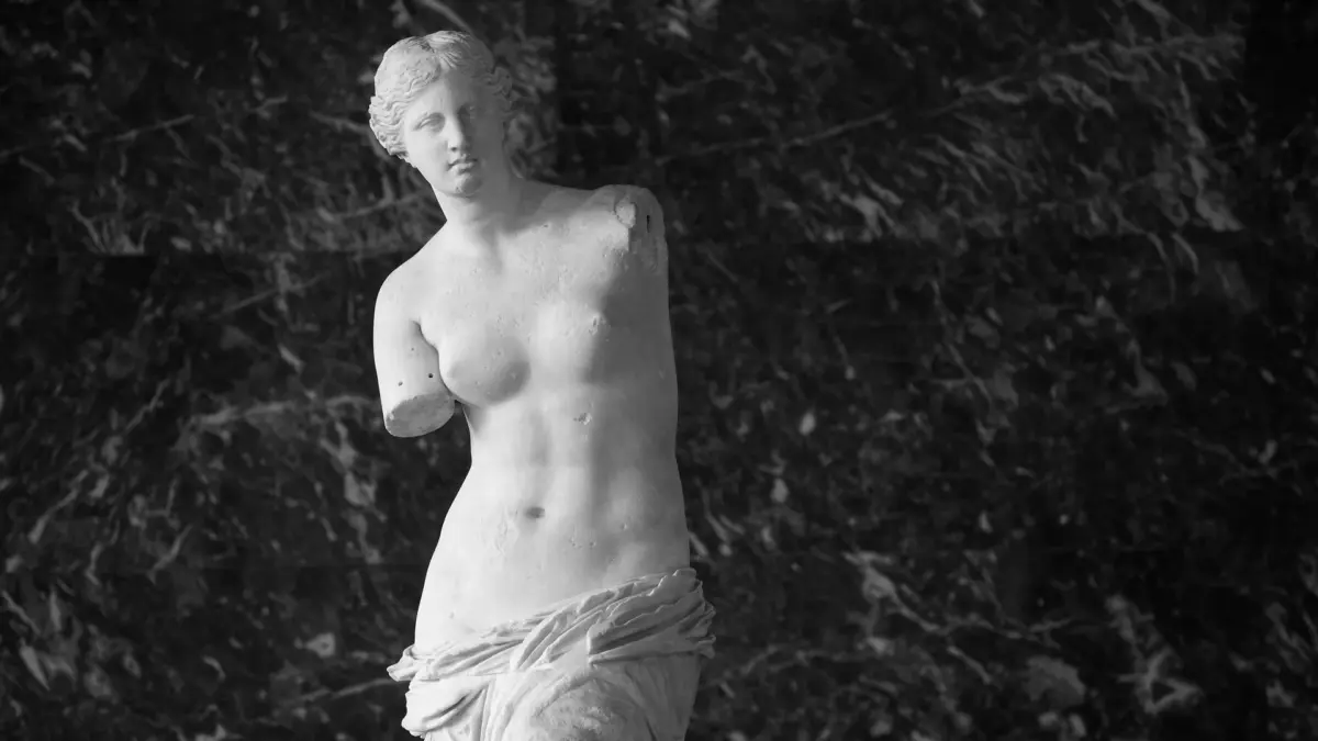 La Vénus de Milo sans bras devant un fond de marbre sombre au Louvre